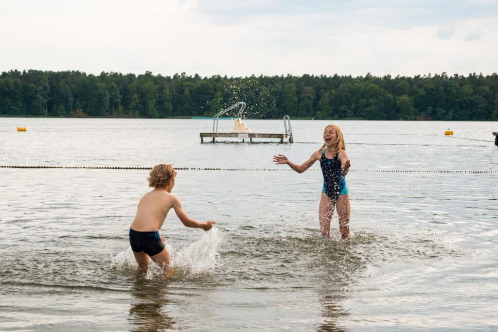 Kinder spielen ausgelassen im Wasser der Mecklenburgischen Seenplatte.